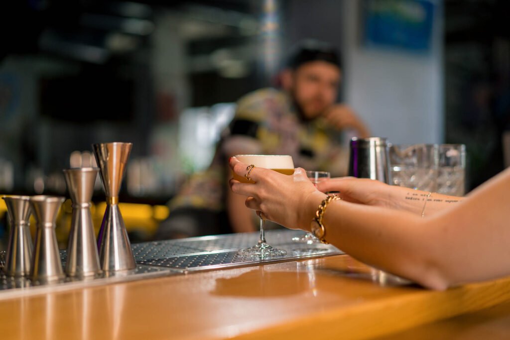 close up of a bar customer's hand taking an alcoholic cocktail f